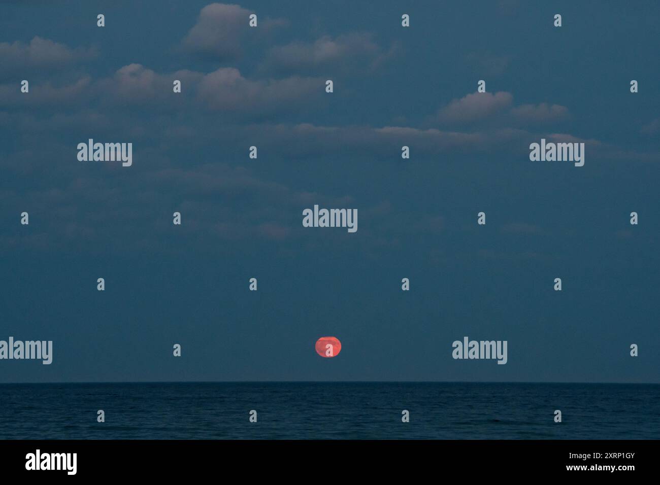 La luna piena sorge sull'Oceano Atlantico Foto Stock