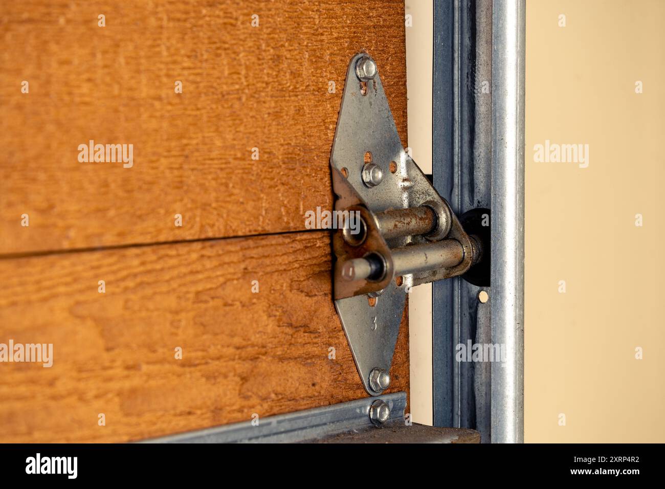Primo piano della cerniera della porta del garage e del rullo sulla porta di legno, messa a fuoco selettiva. Foto Stock