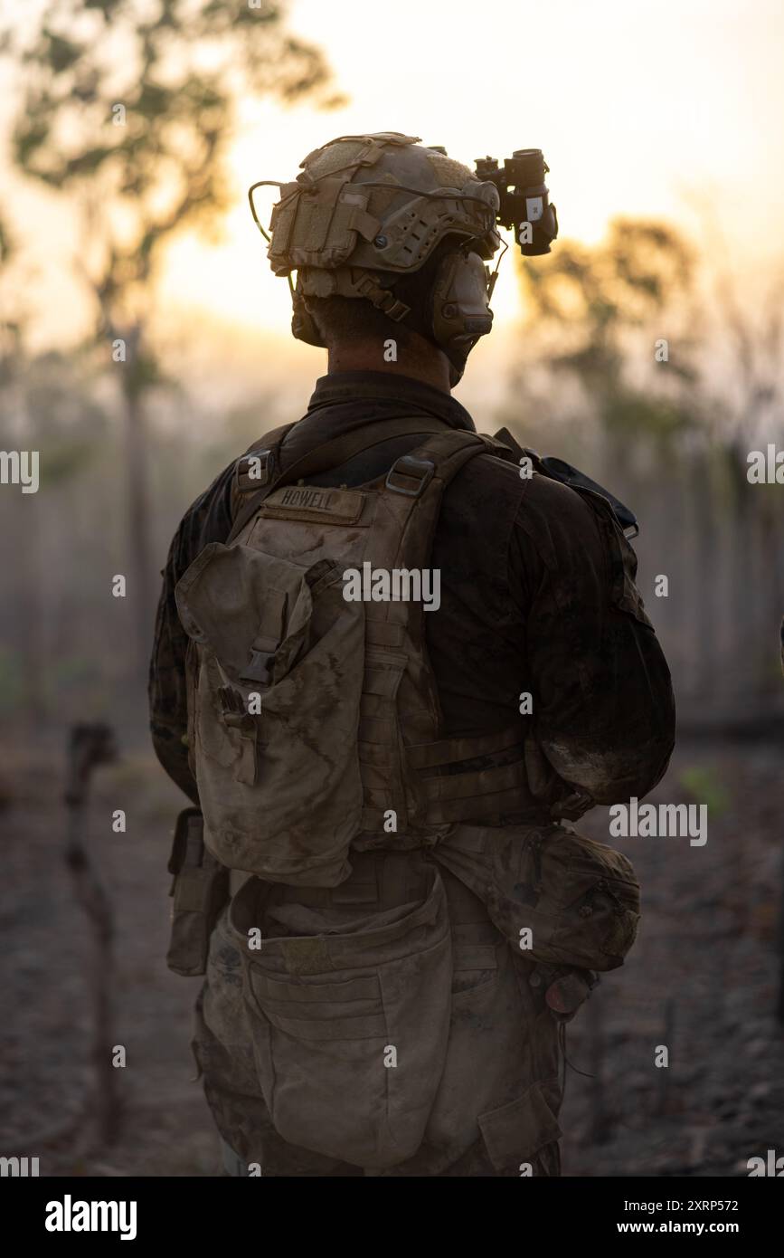 U.S. Navy Petty Officer 3rd Class Brandon Howell, un corpsman con Alpha Company, 1st Light Armored Reconnaissance Battalion, 1st Marine Division, osserva un LAV-25 Light Armored Vehicle che sopprime le posizioni nemiche simulate da un supporto da una posizione di fuoco come parte di un esercizio combinato di armi dal vivo durante l'esercitazione Predator's Run 24 presso Mount Bundey Training area, NT, Australia, 5 agosto 2024. Durante l'esercitazione di Rapid Deployment, il 1st LAR si dispiegò rapidamente dal campo base dei Marines di Pendleton, California, Stati Uniti, in Australia con un ascensore strategico e una ferrovia per partecipare alla 1st Brigade, Australian A. Foto Stock