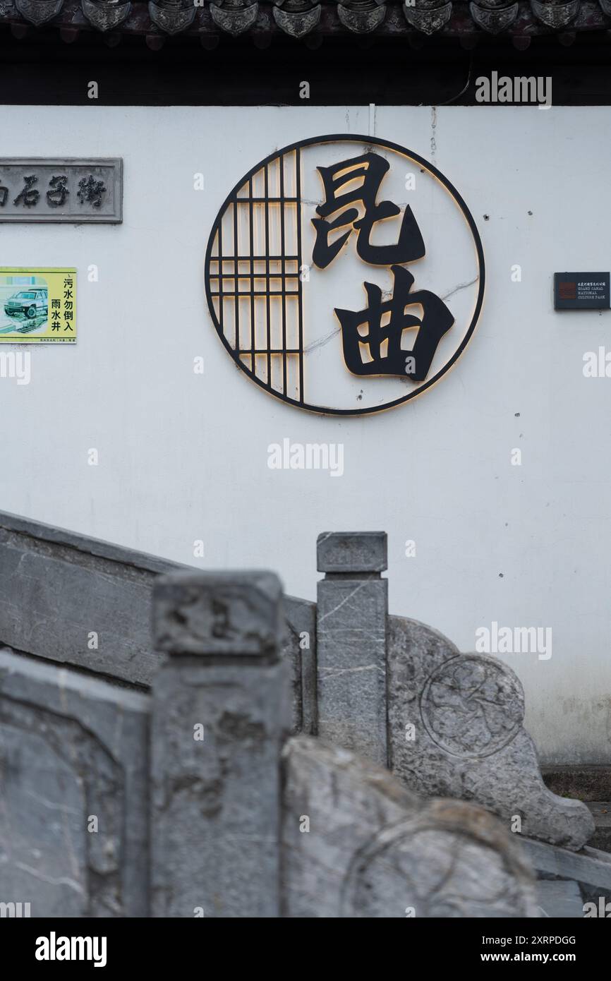 Suzhou, Cina - 11 giugno 2024: Un muro bianco con un segno circolare nero, illuminato da dietro. Foto Stock