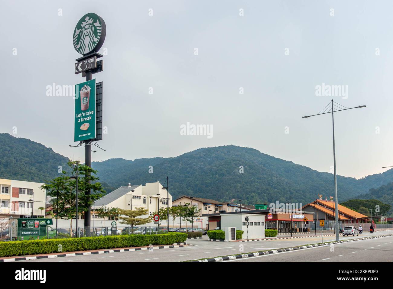 Una vista lungo Jalan Loh Poh Heng, una strada a Tanjung Bungah, Penang, Malesia, con un caffe' Starbucks accanto ad un ristorante Burger King. Foto Stock