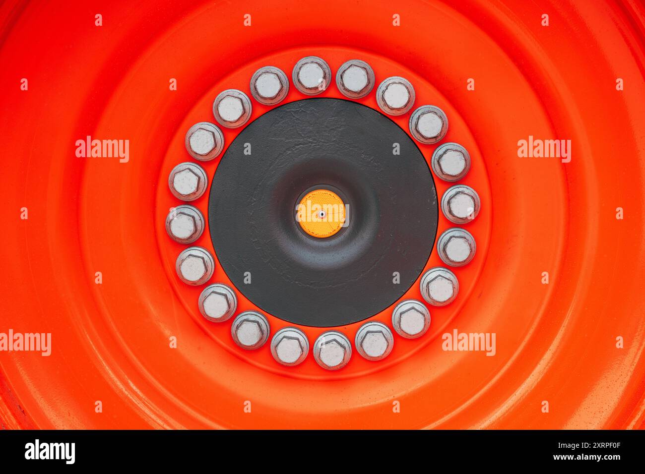 Cerchione della ruota del trattore con controdadi come sfondo Foto Stock