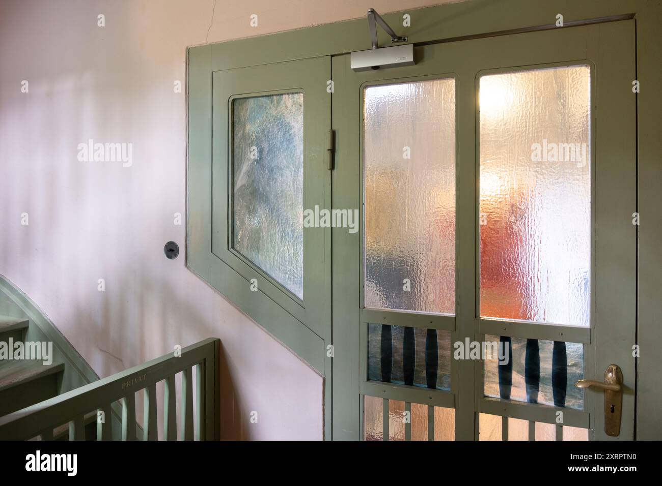 Sala con porta verde con pannelli di vetro accanto a una scala nella Haus Hohe Pappeln, l'ex casa dell'architetto e designer belga in stile Art Nouveau Henry Foto Stock
