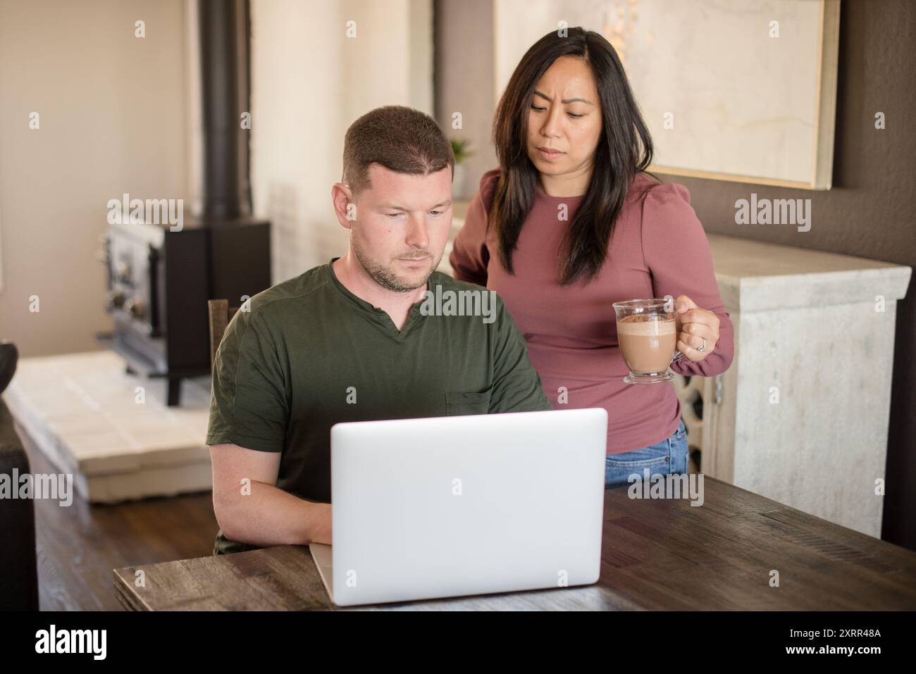 La moglie al posto dei mariti dovrebbe guardare un portatile Foto Stock