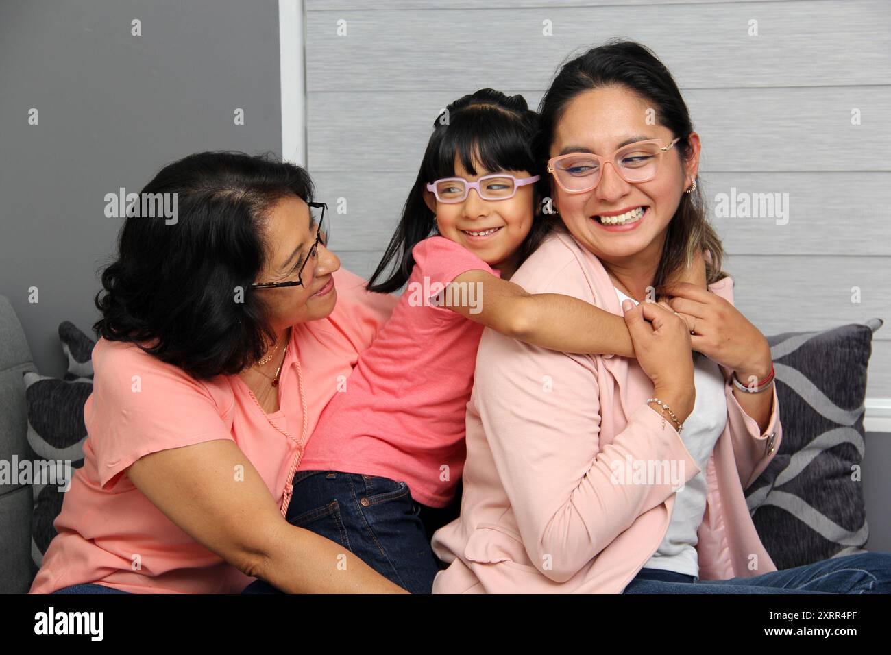 Tre generazioni di donne latine brune: Nonna, mamma e figlia con gli occhiali mostrano il loro amore e celebrano la festa della mamma Foto Stock