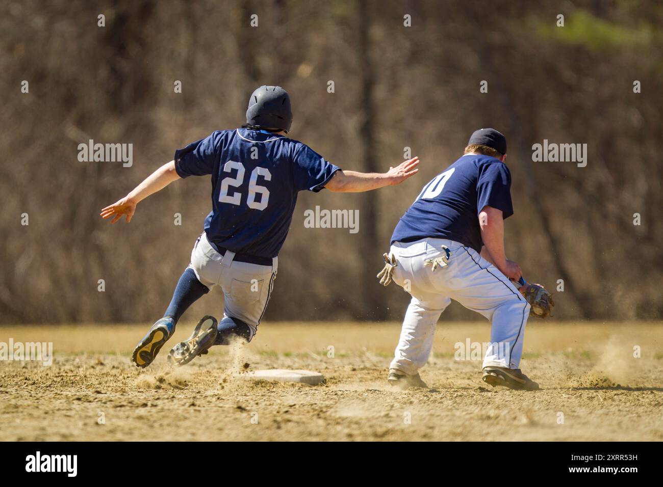 Batter scivola in sicurezza nella seconda base durante una partita di baseball al college Foto Stock