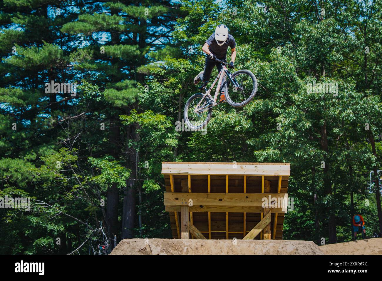 Acrobazie per i motociclisti di un salto all'Highland Mountain Bike Park Foto Stock