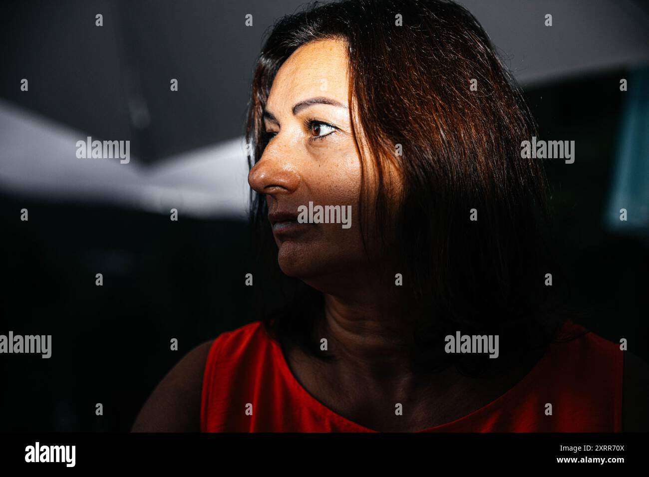 Donna in abito arancione, luce e ombre che creano un effetto drammatico Foto Stock Donna in abito arancione, luce e ombre che creano un effetto drammatico Foto Stock