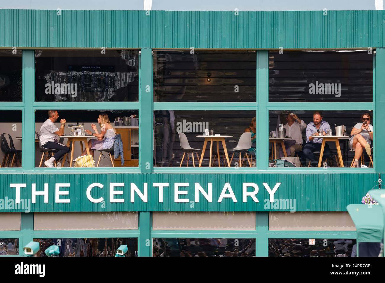 Gli spettatori seduti nel ristorante Centenary si affacciano sui campi del torneo di Wimbledon 2024, Londra, Inghilterra. Foto Stock