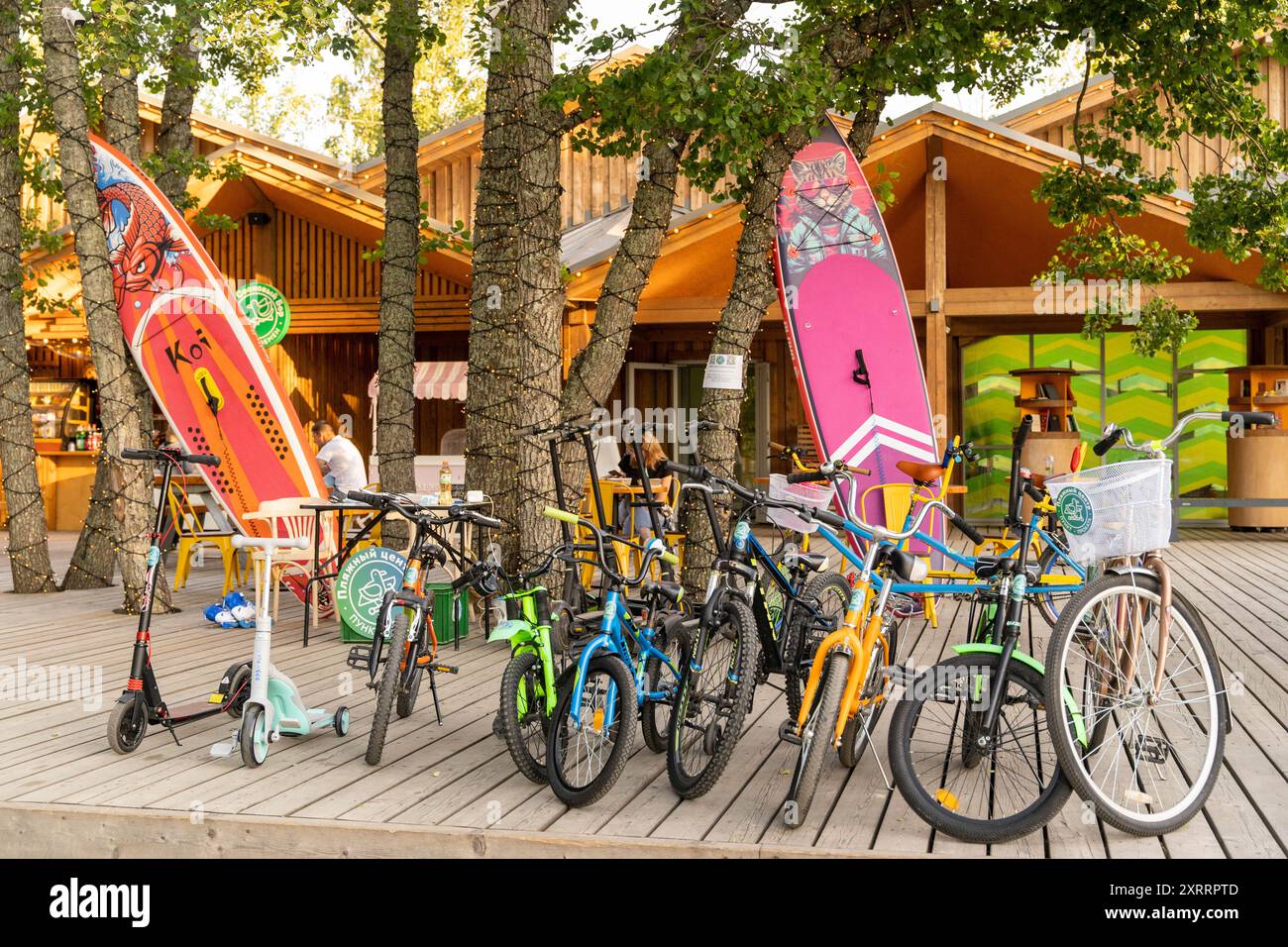 Biciclette e tavole da paddleboard si appoggiano su un edificio in legno in una giornata di sole Foto Stock