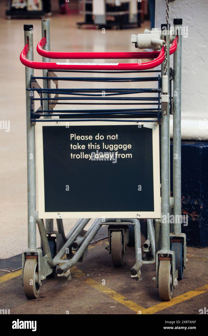 Carrelli per bagagli impilati alla stazione di York con un cartello per tenerli all'interno dell'hotel Foto Stock