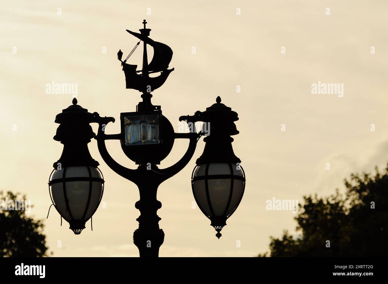 Lampione stradale vintage con design della nave al tramonto a Londra, Inghilterra. Foto Stock
