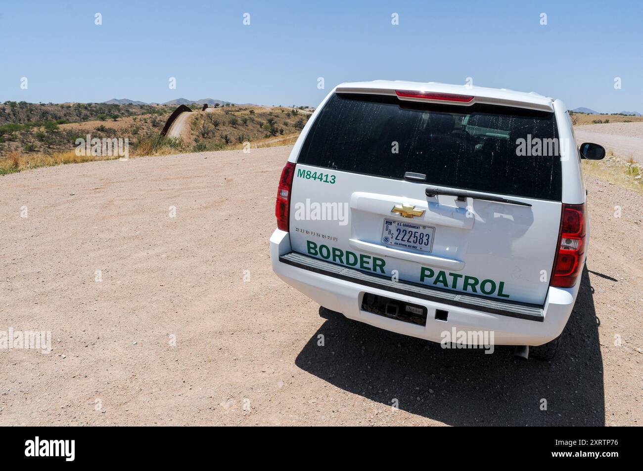Un veicolo di pattuglia di confine vicino al confine tra Messico e Stati Uniti a Nogales, in Arizona, con il muro di confine a sinistra visibile, che divide entrambi i paesi Foto Stock