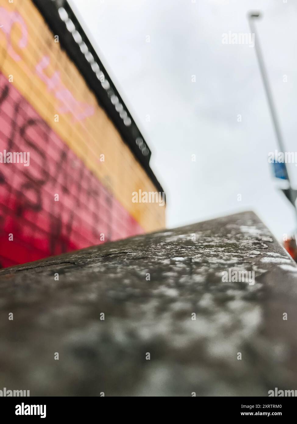 Un edificio coperto di graffiti con un cartello sul lato che dice "nessun parcheggio". L'edificio è circondato da un muro di cemento e da una ringhiera in metallo. Il cielo Foto Stock
