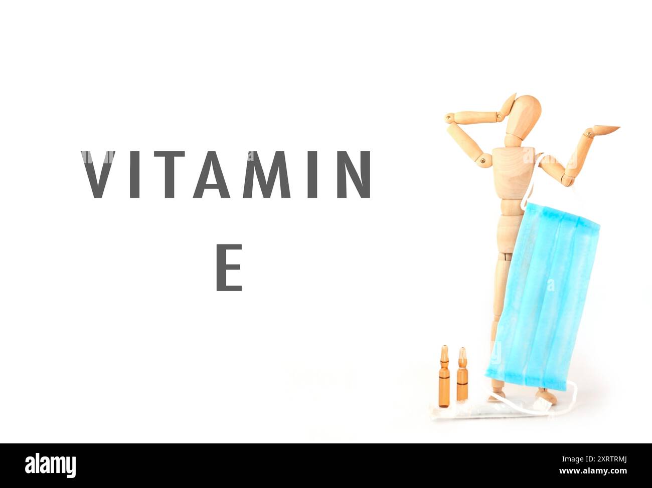 Un uomo ha una maschera blu e la parola vitamina e è scritta sotto di lui. Concetto di prendersi cura della propria salute e l'importanza delle vitamine Foto Stock