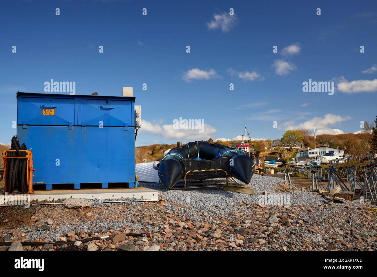 Serbatoio del gasolio e gommone nell'area di lavoro del cantiere navale e del porticciolo di Arisaig, Lochaber, Invernes-shire, Scozia. Foto Stock