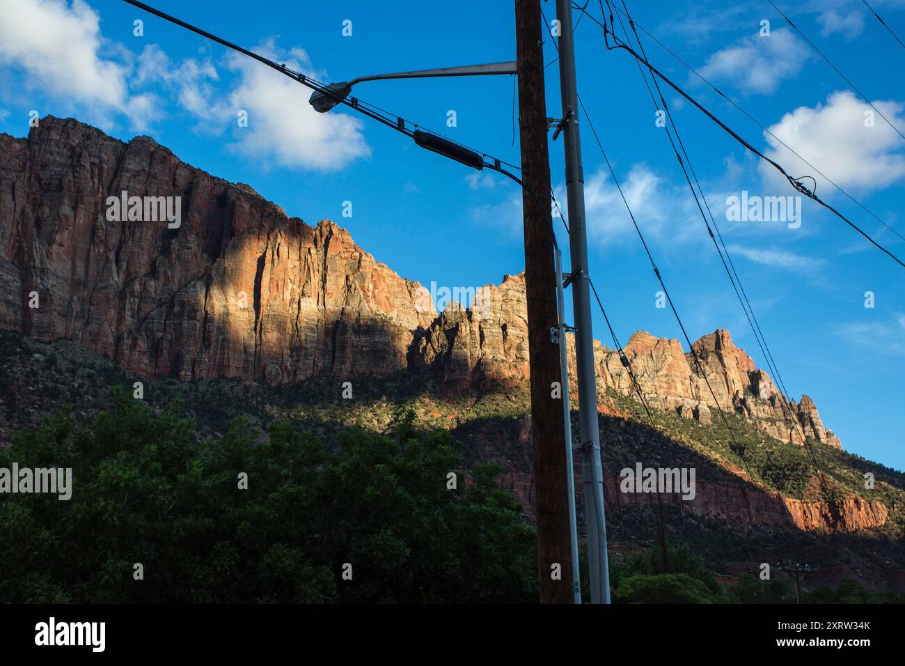 Vista delle creste di montagna nel Parco Nazionale di Zion, Utah, Stati Uniti, con fili appesi ai pali del telegrafo. Foto Stock