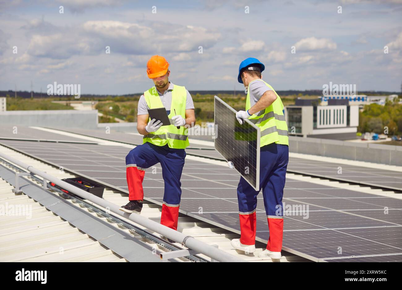 I riparatori stanno mantenendo e installando pannelli solari su un tetto. Foto Stock