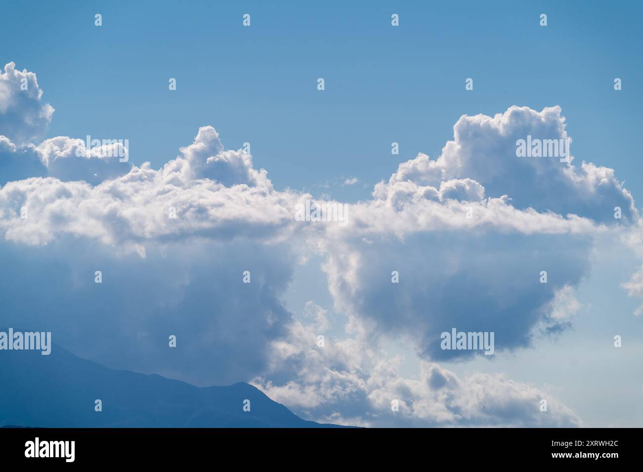 In un pomeriggio estivo, eleganti nuvole bianche ballano nel cielo blu. Il paesaggio sereno e affascinante testimonia la bellezza della natura. Taiwan. Foto Stock