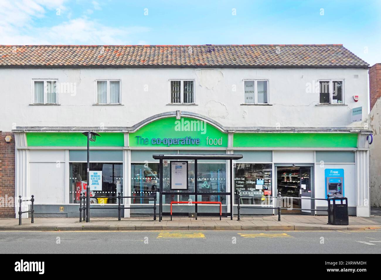 La Food Co-operative Shoppers firma la facciata del negozio e vetrine accanto alla fermata dell'autobus buca nel bancomat a muro Sedgefield County Durham Inghilterra Regno Unito Foto Stock