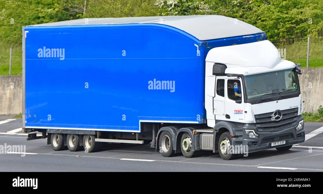 Supermercato Tesco bianco, veicolo industriale Mercedes hgv con motore di lusso, semirimorchio blu a corpo rigido combinato sull'autostrada M25 Essex Inghilterra Regno Unito Foto Stock