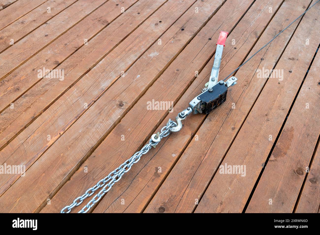 Meccanismo di sollevamento a catena posizionato su un ponte in legno per le attività di sollevamento. Foto Stock