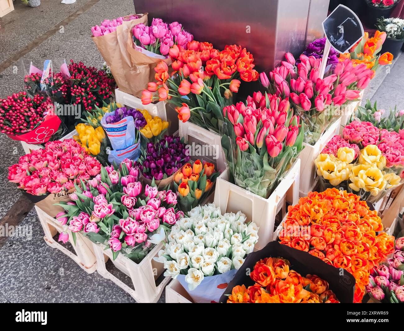 Una colorata esposizione di fiori in casse di legno. I fiori sono disposti in modo da creare un'atmosfera vivace e vivace Foto Stock