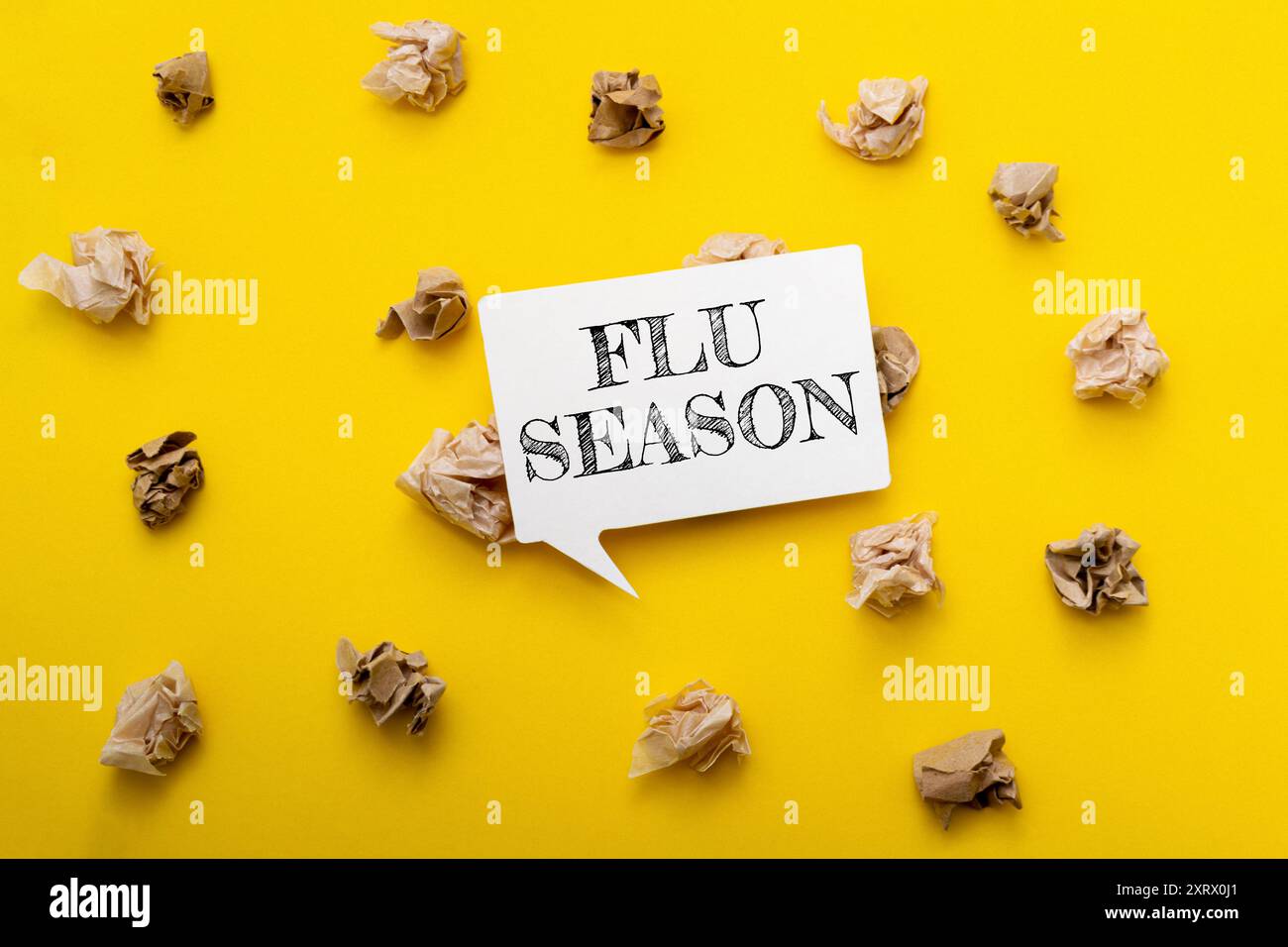 Uno sfondo giallo con un segno bianco che dice stagione influenzale. Il cartello è circondato da carta increspata Foto Stock