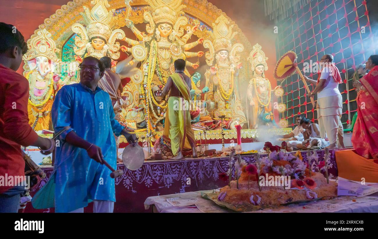 Howrah, Bengala Occidentale, India - 5 ottobre 2022: Dhaakis che gioca a dhaak per adorare la dea Durga, mentre alla dea viene offerto VOG, cibo sacro dolce. Foto Stock