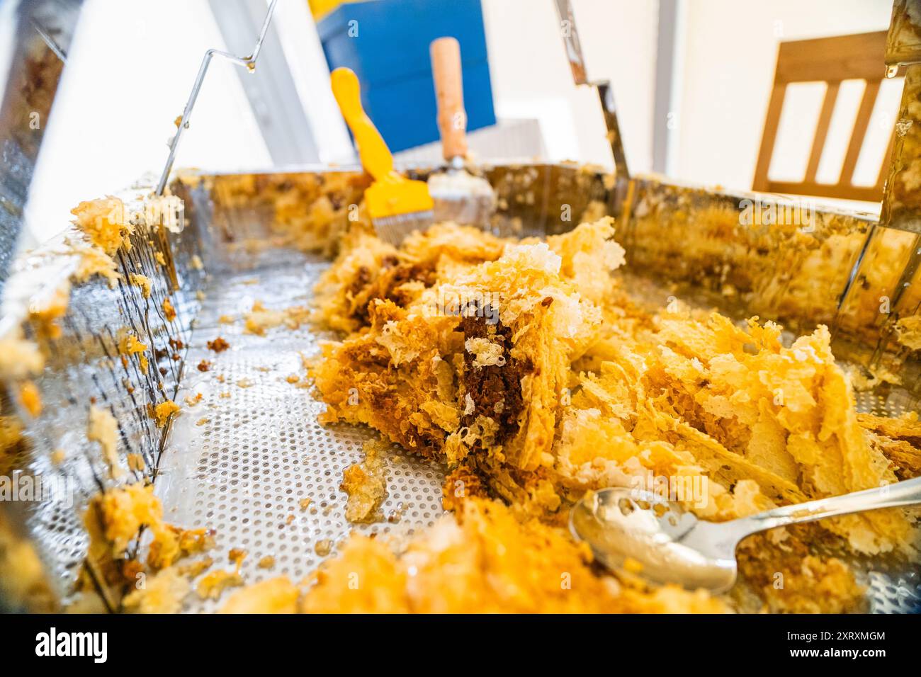 Cera d'api raccolta in un vassoio di raccolta in metallo dopo la raccolta del miele di api Foto Stock