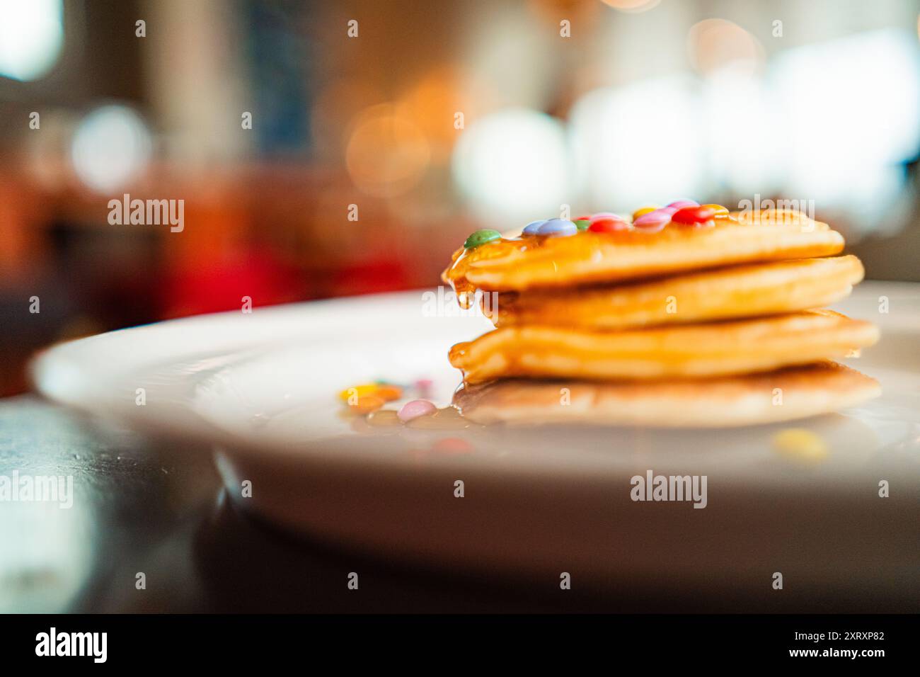 Pila di pancake con miele d'ape e lenticchie al cioccolato come condimento Foto Stock