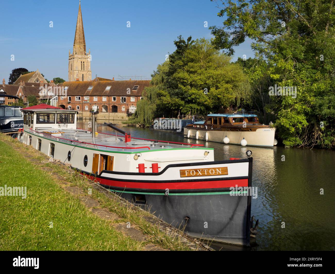 Case galleggianti ormeggiate sul Tamigi ad Abingdon. Una bella vista del Tamigi ad Abingdon, nelle prime ore di una mattina d'estate. Siamo sulla riva sud del fiume, guardando dall'altra parte verso la chiesa anglosassone di Sant'Elena da cui prende il nome il molo. Foto Stock