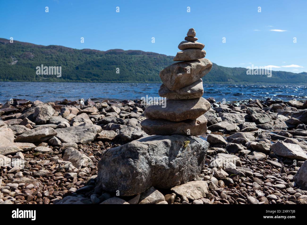 Un gruppo di rocce impilate l'una sull'altra, situate su una spiaggia coperta da terreno roccioso. Foto Stock