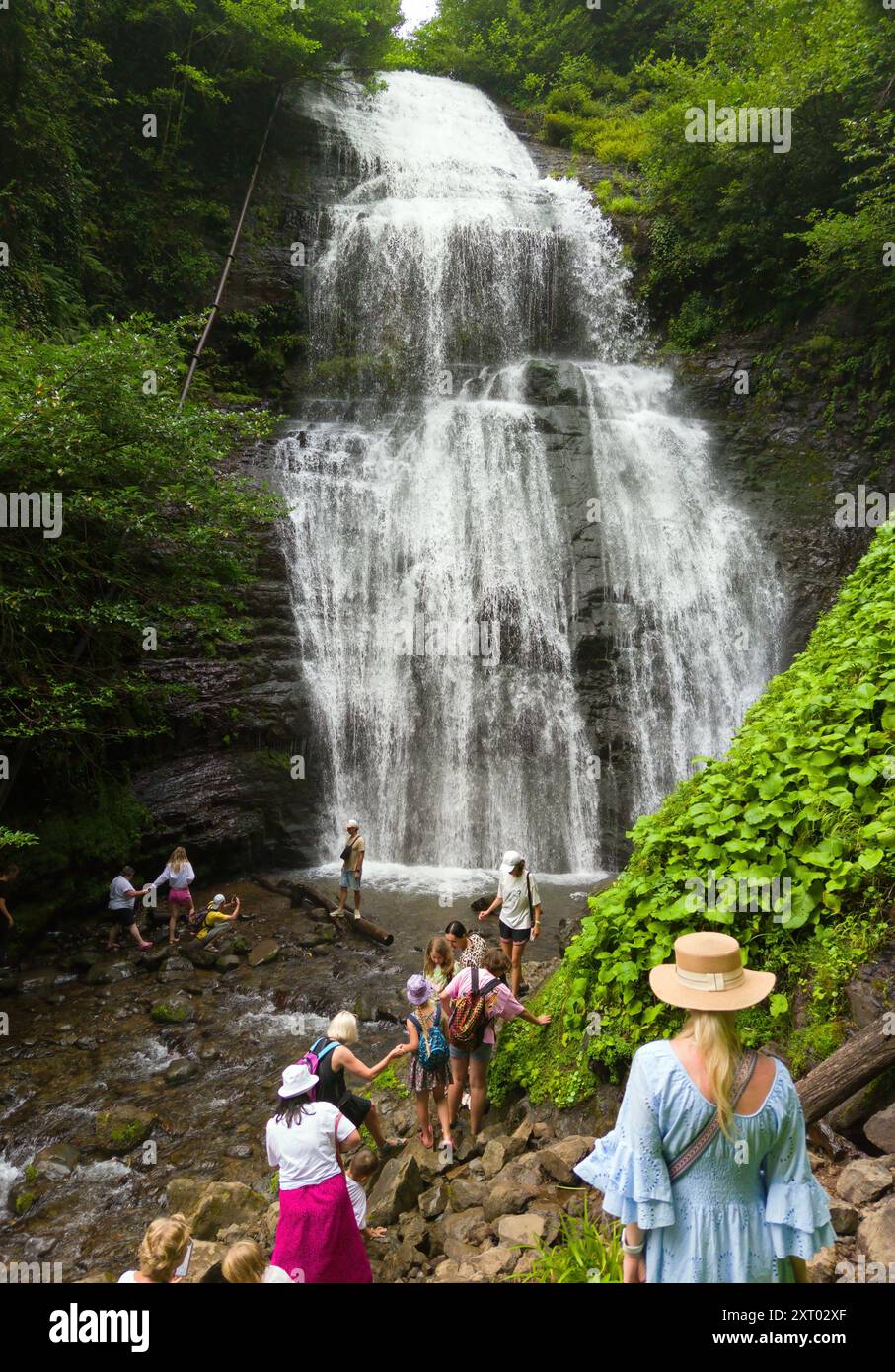 La gente visita la cascata Irina in Abkhazia, grande primavera in montagna in estate, punto di riferimento naturale. Concetto di foresta, acqua, natura, paesaggio, viaggio Foto Stock