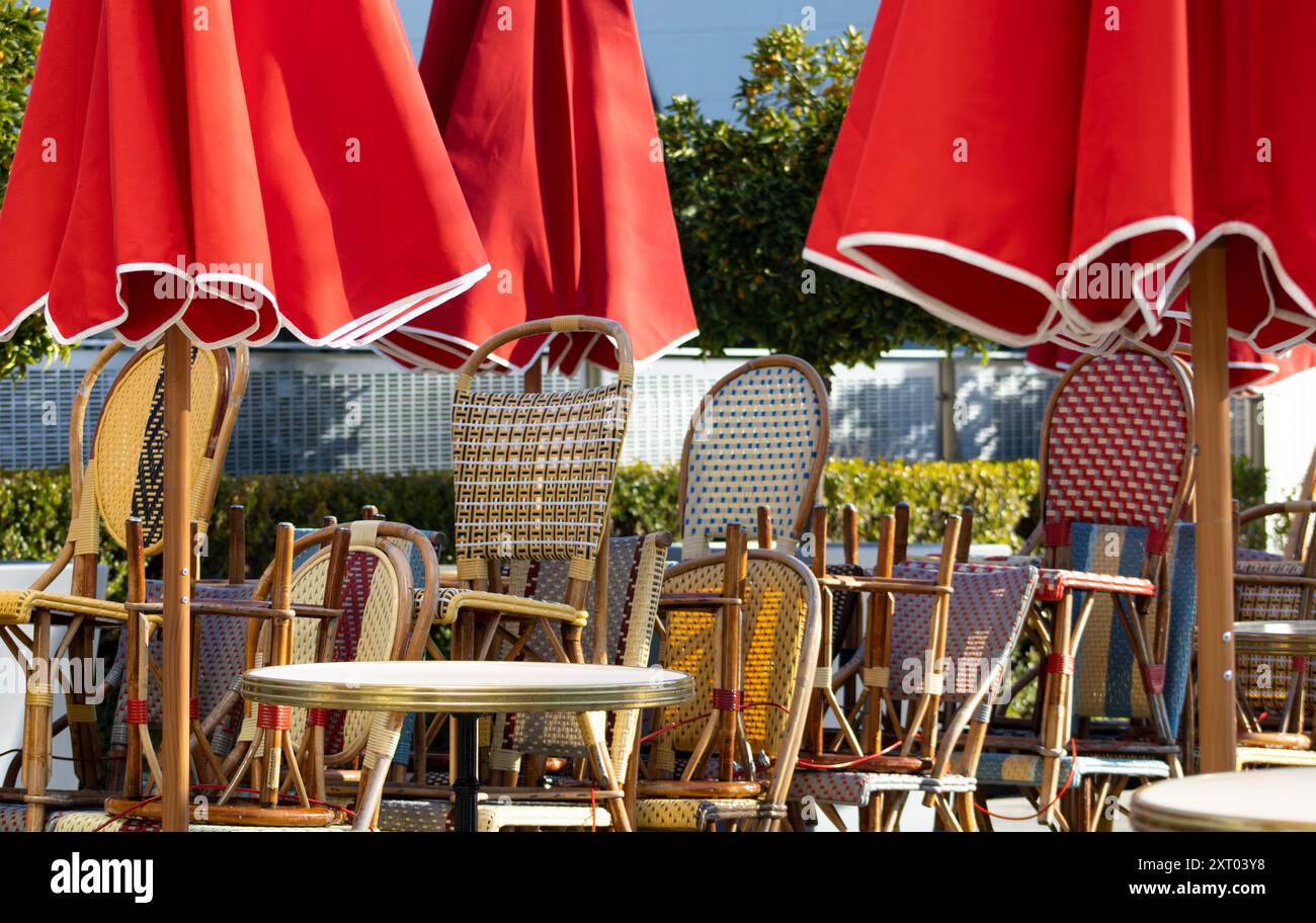 sedie da bistrot sotto gli ombrelli rossi Foto Stock