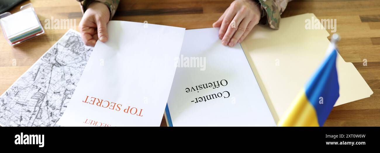 Uomo militare che tiene in mano piani segreti di operazione Ucraina controffensiva Foto Stock