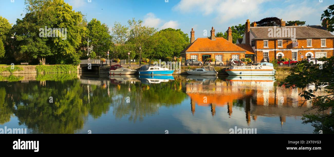 Saint Helen's Wharf è un famoso luogo di bellezza sul Tamigi, appena a monte del ponte medievale di Abingdon-on-Thames. Il molo è stato per secoli un importante collegamento di trasporto e trasporto marittimo sul Tamigi e tra i canali da Oxford e le Midlands. Belle case mercantili si incrociano con case di elemosina e la chiesa di Sant'Elena di epoca sassone. Qui vedremo imbarcazioni da diporto e case ormeggiate lungo le Long Alley Alms Houses, viste in una bella giornata di mezza estate dalla riva nord del fiume. Foto Stock