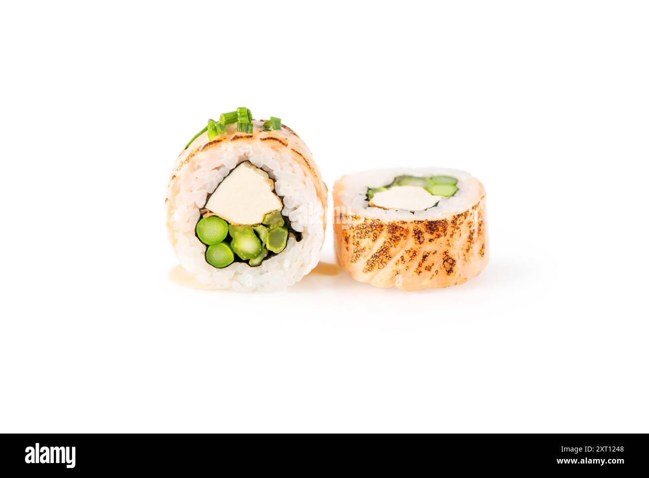 Primo piano di due pezzi di sushi tostato con formaggio spalmabile e ripieno di asparagi, su uno sfondo bianco e croccante, evidenziandone i colori vivaci e il de Foto Stock