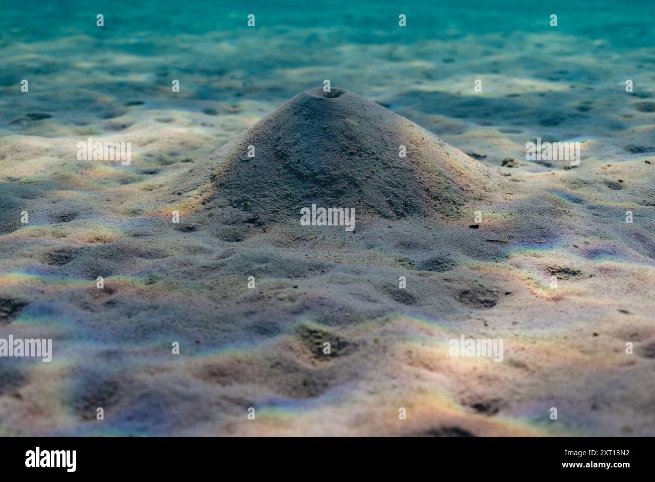 Sfondo subacqueo di un profondo oceano turchese trasparente con luce solare e ombra sul fondo sabbioso dell'oceano nelle insenature di Minorca Foto Stock