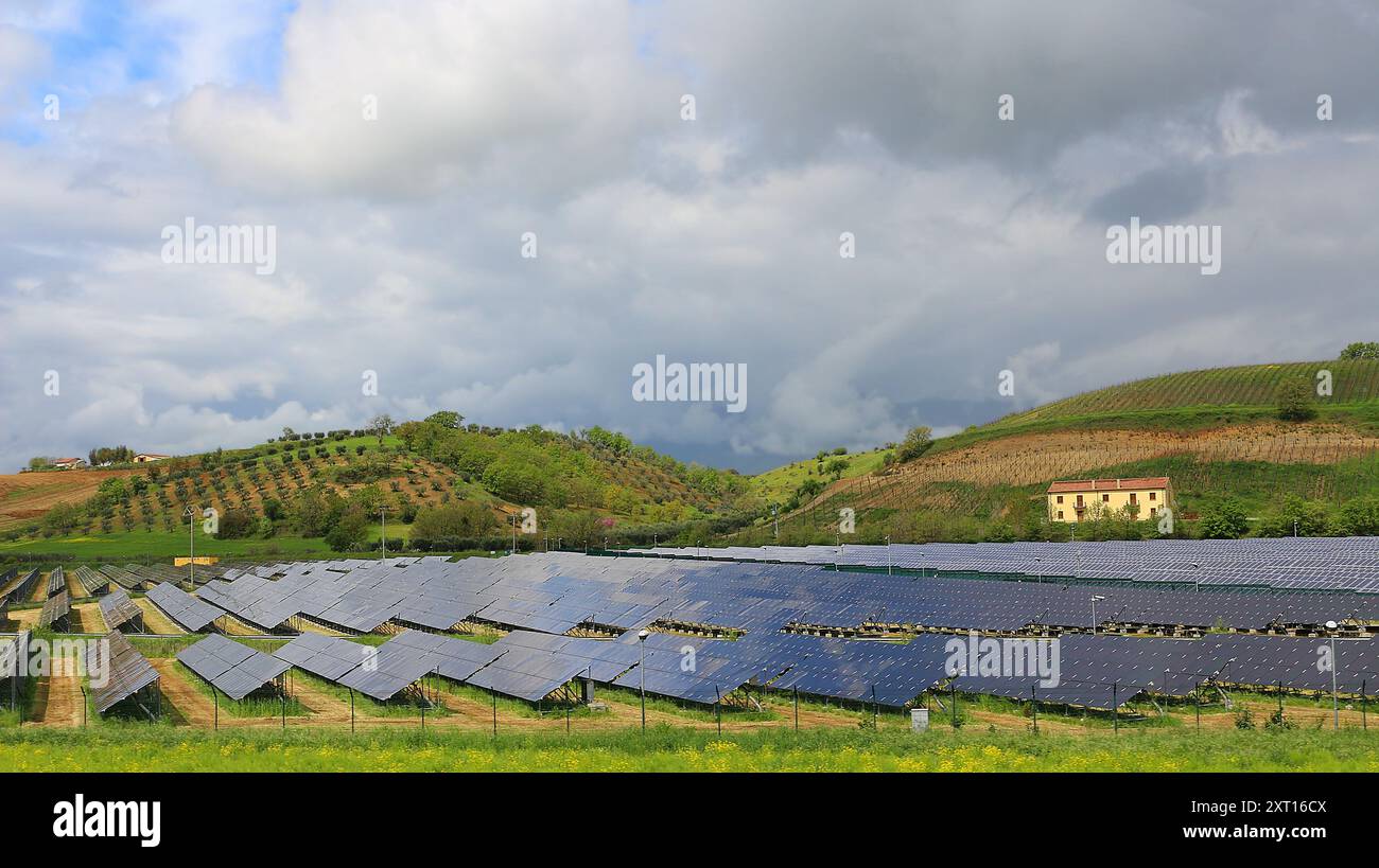 Paesaggio coltivato con pannelli solari campi circondati da oliveti A Calabria (Italia) Foto Stock
