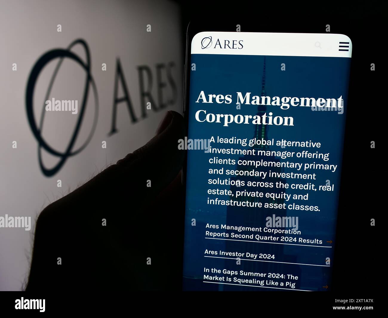 Persona che detiene un cellulare con pagina web della società di investimento statunitense Ares Management Corporation davanti al logo. Messa a fuoco al centro del display del telefono. Foto Stock
