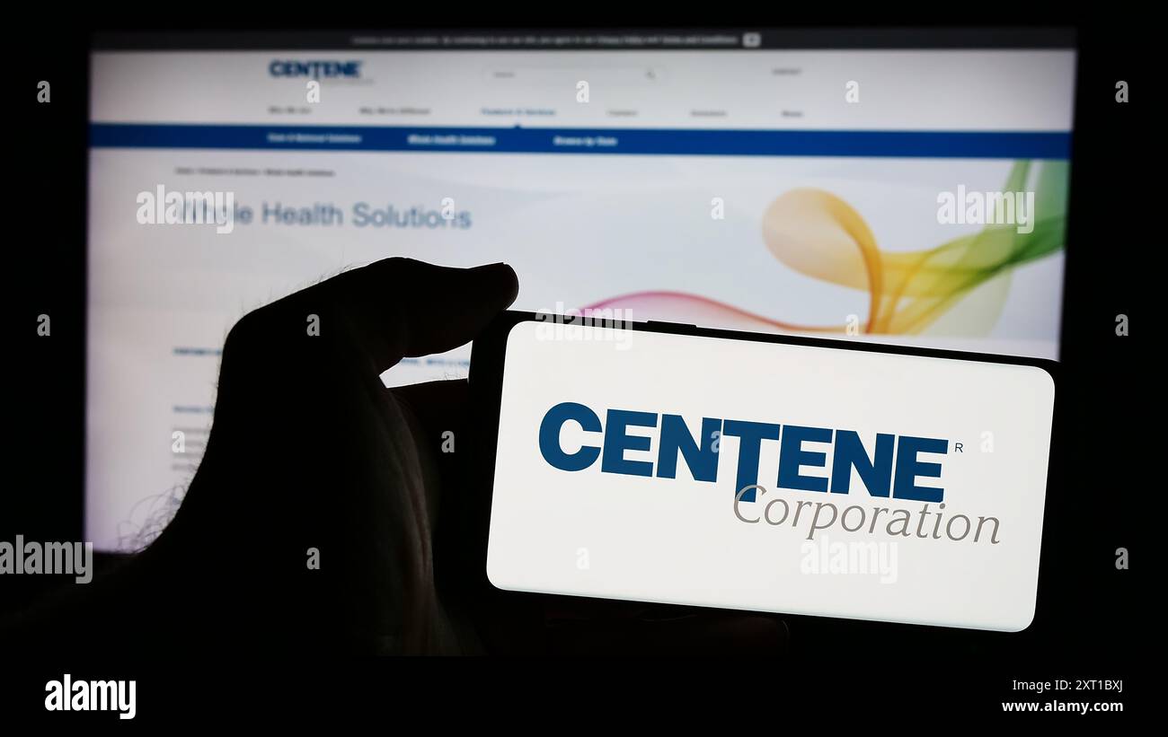 Persona che possiede uno smartphone con il logo della società di assistenza gestita dagli Stati Uniti Centene Corporation davanti al sito Web. Mettere a fuoco il display del telefono. Foto Stock