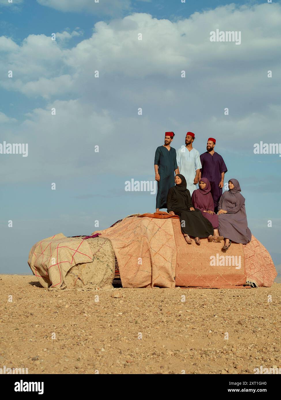 Gruppo di individui vestiti tradizionalmente, che posano insieme su una grande roccia sotto un cielo nuvoloso. Bola02601 Copyright: XConnectxImagesx Foto Stock