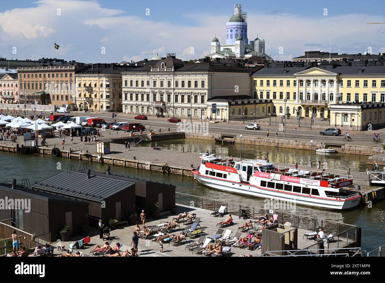 Helsinki, Finlandia - 25 luglio 2024: Un popolo si riposa vicino al porto di Helsinki in estate giorno di sole. Foto Stock