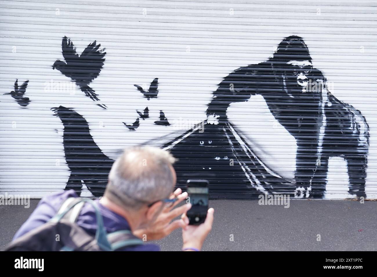 La nuova opera d'arte svelata da Banksy allo Zoo di Londra, raffigurante un gorilla che solleva un otturatore all'ingresso consentendo a un certo numero di uccelli di fuggire, mentre gli occhi di altri animali possono essere visti in agguato nell'oscurità, la nona opera d'arte della sua collezione a tema animale. Data foto: Martedì 13 agosto 2024. Foto Stock