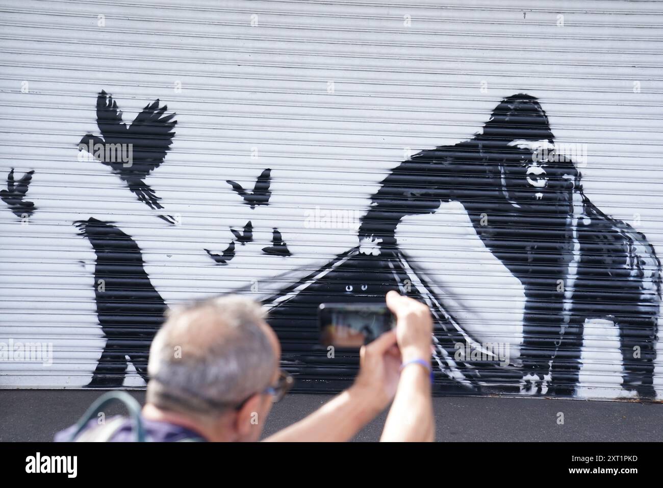 La nuova opera d'arte svelata da Banksy allo Zoo di Londra, raffigurante un gorilla che solleva un otturatore all'ingresso consentendo a un certo numero di uccelli di fuggire, mentre gli occhi di altri animali possono essere visti in agguato nell'oscurità, la nona opera d'arte della sua collezione a tema animale. Data foto: Martedì 13 agosto 2024. Foto Stock