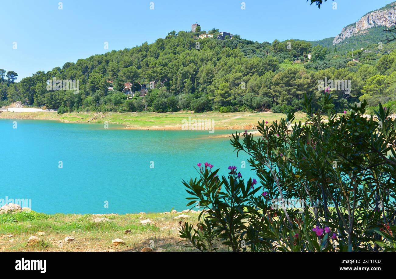 Lago artificiale della diga di Revest les Eaux con la torre Sarasine in cima al villaggio Foto Stock