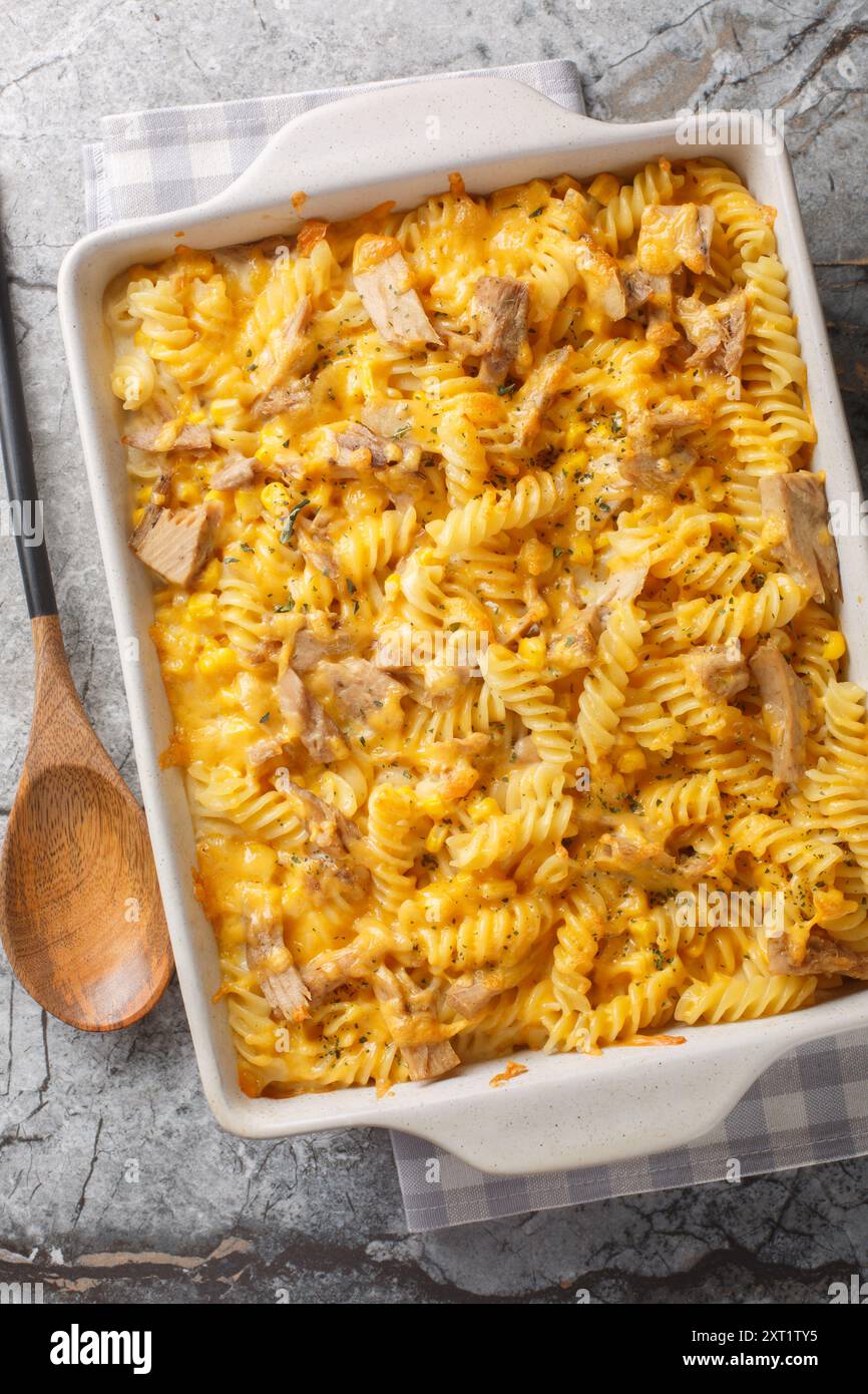 Casseruola di tonno al forno con pasta fusilli, salsa cremosa di Mornay e primo piano di mais sul piatto da forno sul tavolo. Vista dall'alto verticale Foto Stock