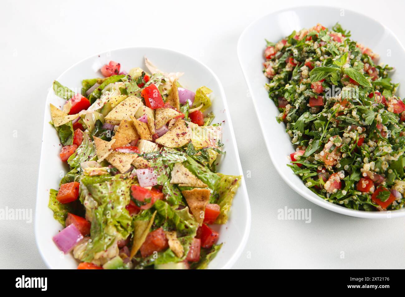 Soffio di insalata araba tradizionale Fattoush e tabbouleh su sfondo bianco Foto Stock