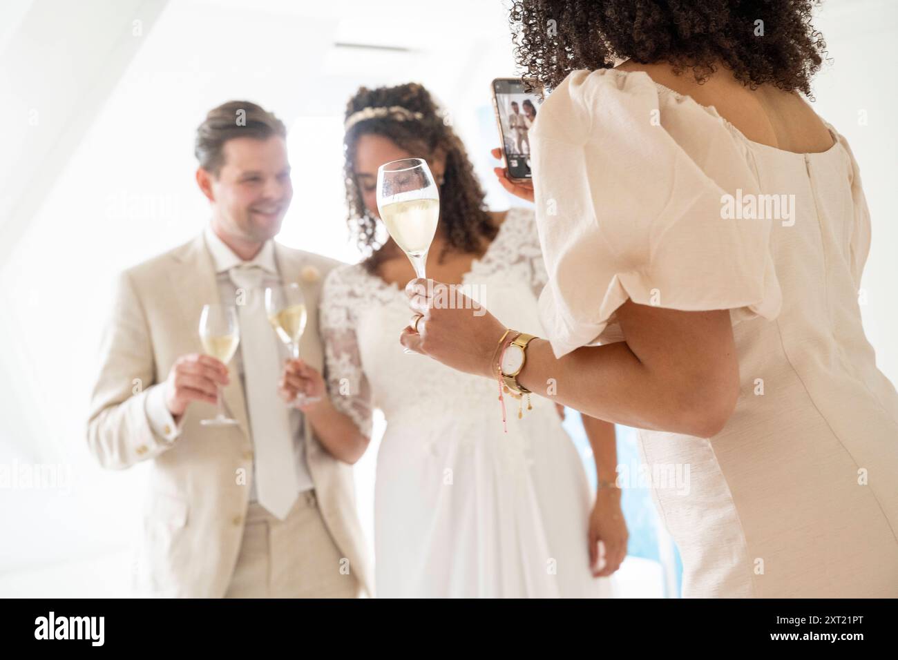 Sposa e sposo con un ospite in occasione di una celebrazione di matrimonio, con un brindisi. Panc05931 Copyright: XConnectxImagesx Foto Stock